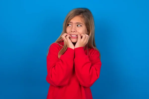 Terrified Blonde Teen Girl Wearing Red Sweater Blue Wall Looks — Stock Photo, Image