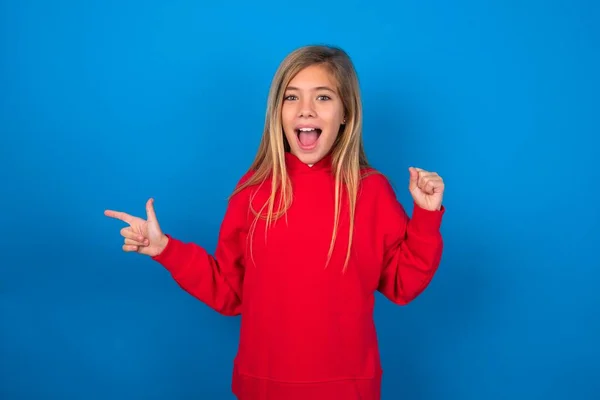 Blonde Teen Girl Wearing Red Sweater Blue Wall Points Empty — Stock Photo, Image