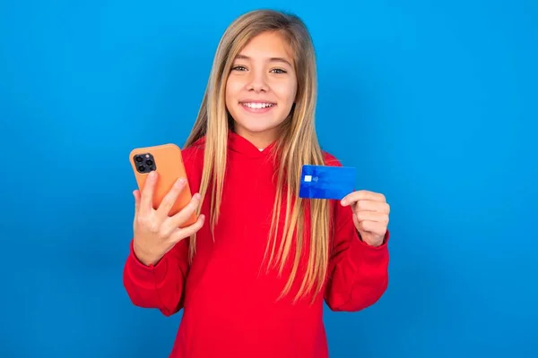 Blondes Teenie Mädchen Trägt Roten Pullover Über Blauer Wand Trägt — Stockfoto