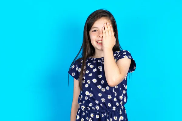 Menina Criança Bonita Vestindo Vestido Sobre Fundo Azul Cobrindo Olhos — Fotografia de Stock
