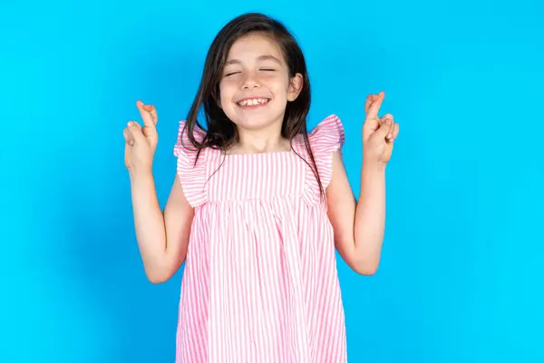 Piękne Dziecko Dziewczyna Różowej Sukience Niebieskim Tle Gestykulujący Palec Skrzyżowany — Zdjęcie stockowe
