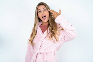 Kafkasyalı genç bir kadın şakaklarında bornoz şapşallığı takıyor parmaklarıyla tapınakta çekimler yapıyor ve intihar jesti yapıyor. Komik manken parmak tabancası yapar.