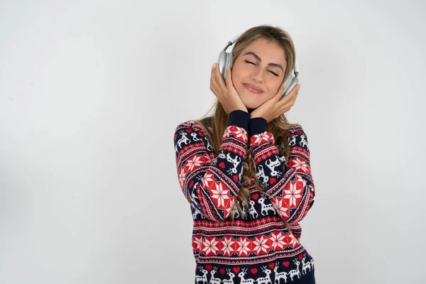 Zufriedene Kaukasierin Weihnachtspullover Hört Angenehme Melodie Hält Die Hände Auf — Stockfoto