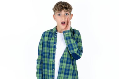 Beyaz stüdyo arka planındaki yakışıklı beyaz çocuk şaşırmış, şaşırmış ve şaşırmış görünüyor. Beklenmedik haberler, yüz ifadeleri konsepti....