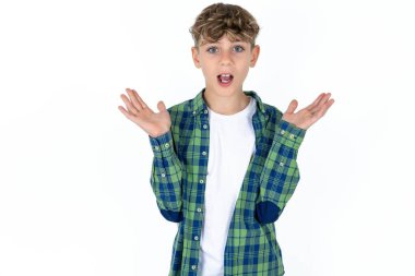 Beyaz stüdyo arka planında korkmuş yakışıklı beyaz çocuk belirsizlikle jestler yapıyor, kameraya bakıyor, şaşırmış bir şekilde hileli soruya cevap vermiyor, insanlar, vücut dili, duygu konsepti