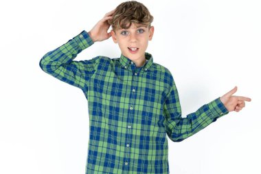 Beyaz stüdyo arka planındaki yakışıklı beyaz çocuk el ele tutuşarak boş alanı işaret ediyor.