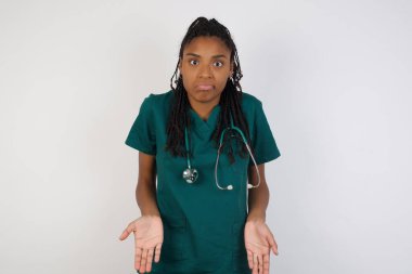 Kafası karışmış, kolları açık genç bir doktor kadın omuzlarını silkip: 