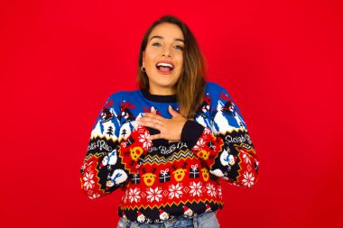 Mutlu Gülümseyen Model 'in göğsüne yakın eller vardır. İnsani duygular, gerçek duygular ve yüz ifadesi kavramı.