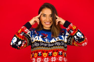 Model ciddi bir bakışla bir fikir üzerinde yoğunlaşır, iki işaret parmağı alnı işaret ederek düşünür.