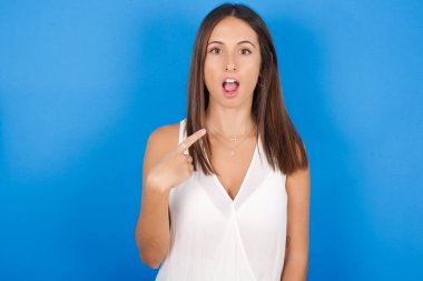 Güzel, genç bir kadın sersemlemiş bir şekilde kendini işaret ederek 