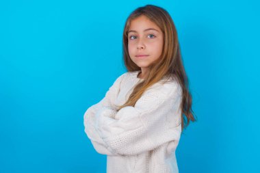 Kollarını kavuşturup gülümseyen güzel bir genç kızın portresi.