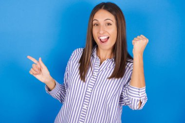 Güzel genç kadın boş yeri işaret ediyor. Yumruğunu kaldır, kazanan jest..