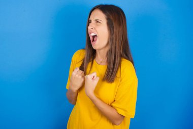 Güzel, genç bir kadın. Zafere ulaştığına sevinmiş ve heyecanlı. Yumruklarını sıkmış, gözleri kapalı çığlıklar atmış..