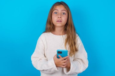 Şaşırmış genç kız fotoğrafı. Akıllı telefondan hoşlanmayan geri bildirim konsepti.
