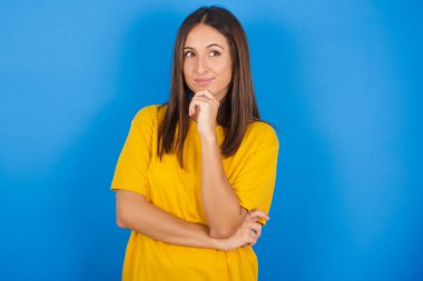 Düşünceli genç bir kadın çenesini tutar ve kafasını çevirir büyük bir plan yapar.