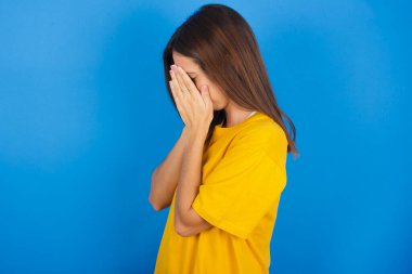 Üzgün, güzel, genç bir kadın. Yüzünü ellerle kapatıp ağlıyor..