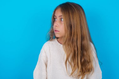 Güzel genç kız şaşırmış bir ifadeyle yan yana bakıyor. Nutku tutulmuş gibi. Utangaç model şaşırmış görünüyor.