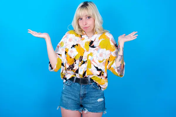 Puzzled Clueless Caucasian Girl Wearing Floral Shirt Isolated Blue Background — Stock Photo, Image