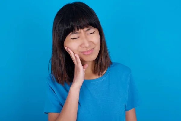 Asyalı Genç Bir Kadın Mavi Arka Plan Diş Ağrısı Tişörtü — Stok fotoğraf