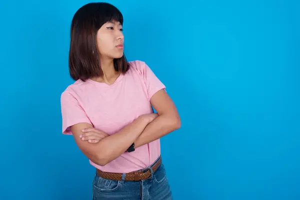 Obraz Zdenerwowanej Młodej Azjatki Noszącej Shirt Niebieskim Tle Skrzyżowanymi Ramionami — Zdjęcie stockowe