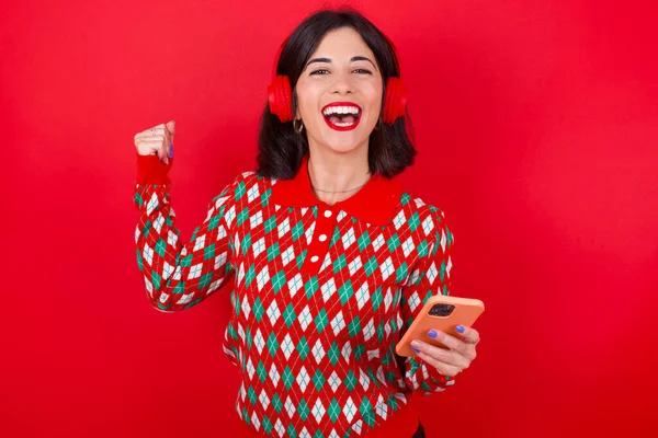 Positive Brunette Caucasian Woman Wearing Christmas Sweater Red Background Holds — Stock Photo, Image