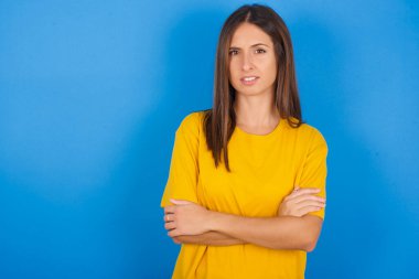 Güzel genç bir kadın, hoşnutsuzca yüzünü buruşturuyor, kollarını kavuşturup, bir açıklama bekliyor..