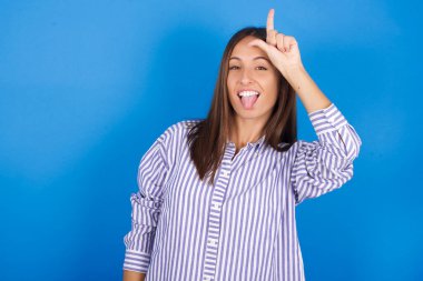 Alnında parmak olan güzel genç bir kadın jestleri kaybedenlerin jestlerini yapar. İnsanlar dil gösterir.