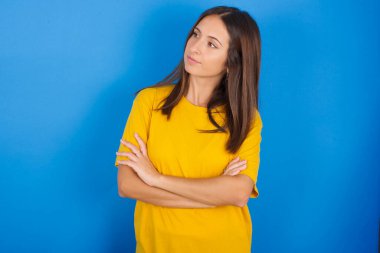 Kollarını kavuşturmuş üzgün genç bir kadının görüntüsü. Kötü haberleri dinledikten sonra hayal kırıklığına uğramış bir ifadeyle bakıyorum..