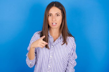 Şok olmuş genç ve güzel bir kadın şaşkın bir ifadeyle seni işaret ediyor.