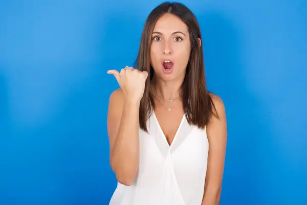 Shocked Beautiful Young Woman Points Thumb Away Indicates Something Check — Stock Photo, Image