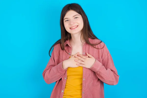 Eerlijk Jong Kaukasisch Meisje Draagt Roze Shirt Geïsoleerd Blauwe Achtergrond — Stockfoto