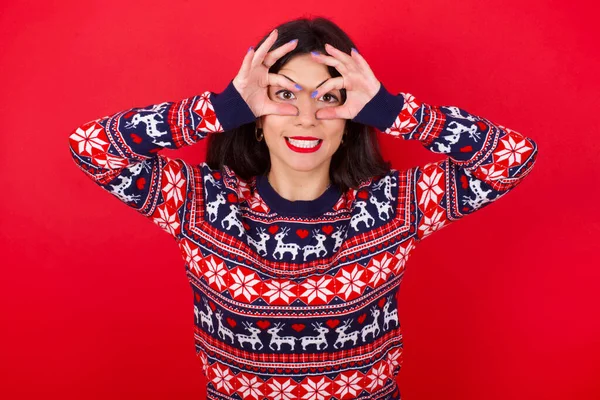 Morena Caucásica Mujer Usando Navidad Suéter Sobre Fondo Rojo Mantener —  Fotos de Stock