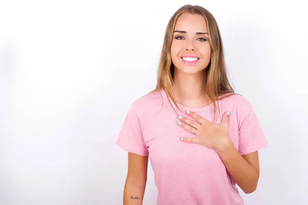 年轻的白种人女孩穿着粉色T恤 白底笑着 简直不敢相信眼睛能表达出良好的情感和惊讶 — 图库照片