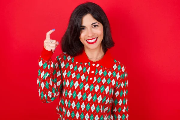Brunette Kaukasische Vrouw Dragen Kerst Trui Rode Achtergrond Wijzen Met — Stockfoto