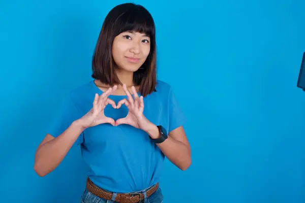 Poważna Młoda Azjatycka Kobieta Niebieskiej Koszulce Niebieskim Tle Trzyma Ręce — Zdjęcie stockowe