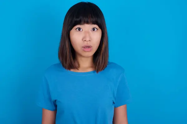 青いバックグラウンドスターに青いTシャツを着てショックを受けた若いアジアの女性は 目が開いたまま口を開け 驚いた表情をしています Omgコンセプト — ストック写真