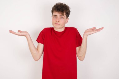 Kafası karışmış, kolları açık, omuzlarını silkmiş, 