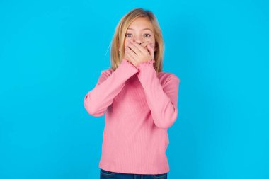 Sersemlemiş genç kız iki eliyle ağzını kapatıyor. Bir şeyden korkuyor ya da çarpıcı dedikodular duyduktan sonra..