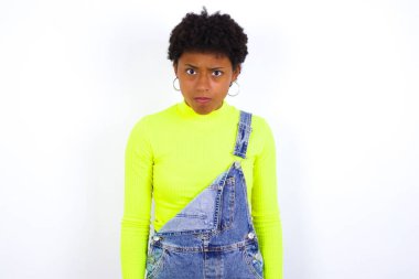 Tatminsiz, kısa saçlı, beyaz duvarlara karşı kot pantolon giyen ve kamerada hayal kırıklığına uğrayan huysuz ifadeli genç Afro-Amerikan kadını gücendirdim.