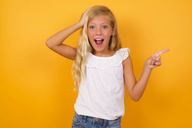 Şok olmuş yüz ifadesi olan güzel bir kızın portresi, şaşırtıcı bir şeyi bir yana bırakırsak, bir eli kafasında ve işaret parmağıyla işaret ediyor. OMG kavramı.