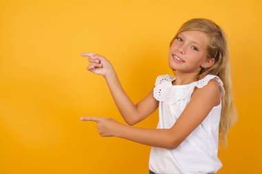 Güzel bir kız, ağzı açık, şaşırmış bir ifadeyle, şaşırtıcı bir şey gösterir. Reklam kavramı.