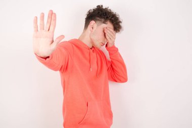 Yakışıklı genç adam avuçla gözlerini kapar ve durarak hareket eder, saklanmaya çalışır. Bana bakma, görmek istemiyorum, utanıyorum ya da korkuyorum..