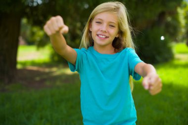 Güzel kız kendini beğenmiş ve mutlu bir şekilde gülümserken iki numarayı işaret ediyor..