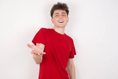 Yakışıklı genç adam dostça gülümsüyor. Karşılama ve hoş geldin demek için elini ya da elini sıkarak bir şey sunuyor. Başarılı bir iş..