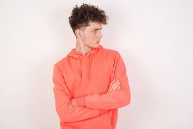 Kollarını kavuşturmuş üzgün bir gencin görüntüsü. Kötü haberleri dinledikten sonra hayal kırıklığına uğramış bir ifadeyle bakıyorum..