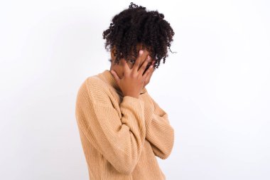 Genç bir kadın elleriyle yüzünü kapatıyor ve bir gözü parmaklarının arasında dışarı bakıyor. Bir şeyden ya da birinden korktun mu?.