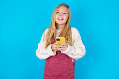 Gülümseyen genç kız dost canlısı ve mutlu bir cep telefonu.