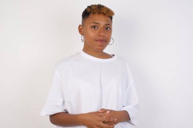 İş Konsepti - Beyaz tişört giyen genç Afrikalı Amerikalı kadın portresi Gri arka planda izole edilmiş kendine güvenen yüzüyle el ele tutuşuyor.