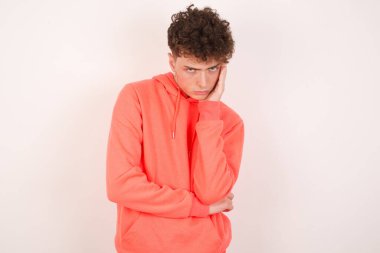 Sıkılmış, yakışıklı bir genç adam el ele tutuşurken diğer eli çapraz tutarak, yorgun ve hasta görünüyor..