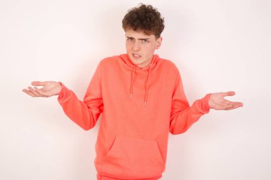 Beyaz arka planda yakışıklı genç bir adam belirsiz omuz silkiyor..